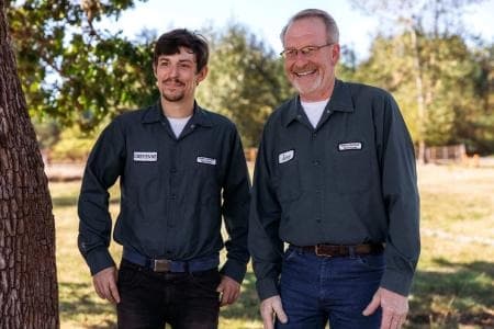 Two Wildwoods technicians standing in a field, ready for a stinging insect job.